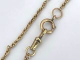 a close up of a gold chain on a white surface
