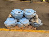 une pile de réservoirs d'eau bleus posés sur une palette dans un parking