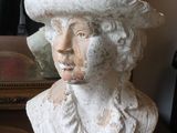 a bust of a woman with a hat on a table
