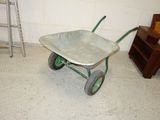 a wheelbarrow in the corner of a room with a ladder