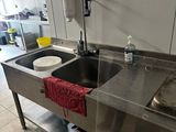 two sinks in the kitchen with a red towel on the counter