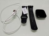 a black apple watch sitting next to a charger and a charger
