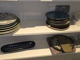 many plates and bowls on the shelves in the kitchen