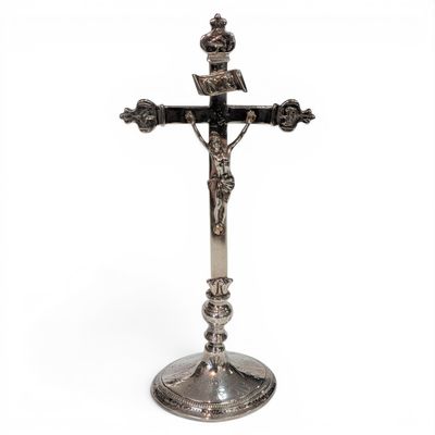 a silver cross on a stand with a crown on top