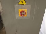 a yellow and black sign on the wall of a room