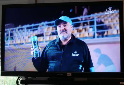un homme qui tient un téléphone portable devant un téléviseur