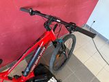 a red bike that is leaning against a pink wall
