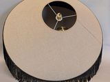 a clock that is sitting on a table with a black fringe around it