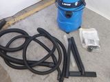 un aspirateur bleu posé par terre à côté d'un tuyau
