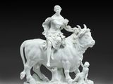 an image of a statue of a woman riding on a cow