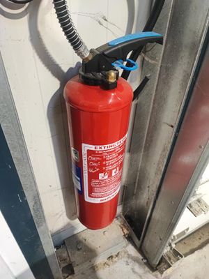 un extincteur fixé sur le mur d'un bâtiment