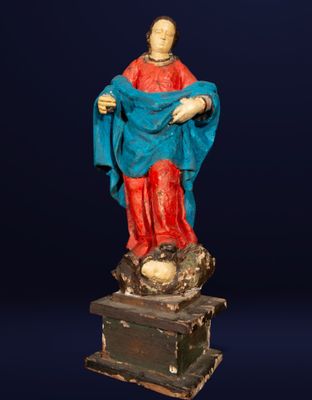 une vieille statue représentant une femme vêtue d'une robe bleue et d'une jupe rouge