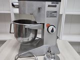 a silver mixer sitting on a table next to a metal bowl