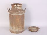 an old milk can with a lid next to a small bowl