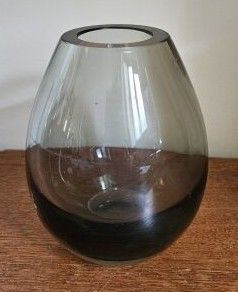un vase en verre posé sur une table en bois