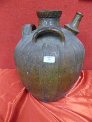 a brown vase with a tag on it on a red cloth