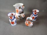 quatre vases différents et un pichet posés sur une table