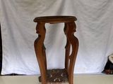 une petite table en bois avec un fond blanc derrière