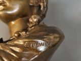 a bronze statue of a woman holding a cell phone