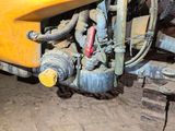 a close up of a yellow truck with a hose attached to the front of it