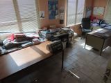 une photo d'un bureau encombré, avec beaucoup de désordre sur le bureau