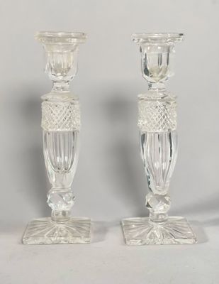 deux bougeoirs en verre transparent posés sur une table blanche