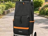 une photo d'un caddie noir et orange posé sur un trottoir
