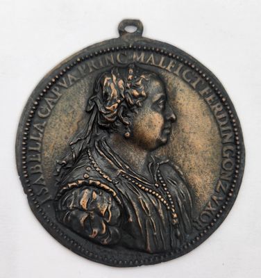 une vieille médaille en bronze représentant une femme avec une fleur dans les cheveux
