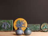 trois vases posés sur une table à côté d'une assiette