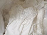 a white wedding dress that is laying on a bed