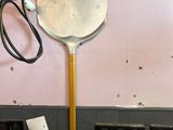 une grande spatule accrochée au mur d'une salle de bains