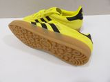 a close up of a pair of yellow and black adidas sneakers
