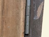 a close up of a wooden door with a metal hinge