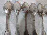 six cuillères sont alignées sur une surface blanche