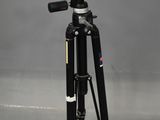 a tripod with a camera on top of it on a gray background