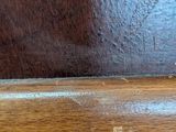 a close up of a wooden table with a knife on it