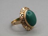 Gros plan sur une bague contenant une pierre verte