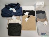 Plusieurs chemises et pantalons pour hommes sont disposés sur une table