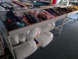 many bags of clothing on a table in a store