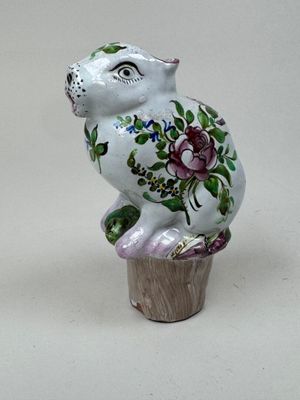 une figurine représentant un chat assis sur un cupcake