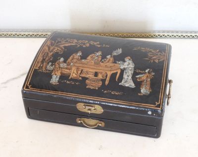 une boîte noire ornée d'une peinture, posée sur une table