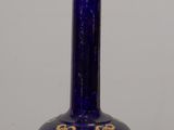 un vase bleu orné d'un motif doré, posé sur une table