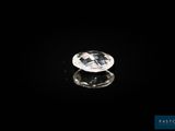 un diamant blanc sur une surface noire, avec un reflet