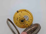 a person holding a pocket watch in their hand