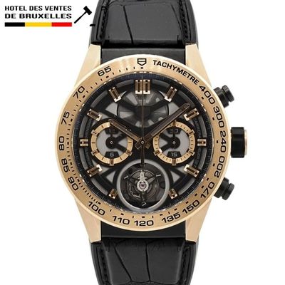 La montre est noire et dorée, avec un bracelet en cuir noir.