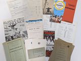several books and pamphlets are stacked on top of each other on a table