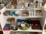 une étagère remplie de vaisselle et de casseroles dans une cuisine