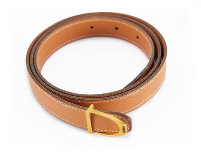 une ceinture en cuir marron avec une boucle dorée sur fond blanc