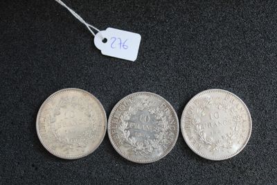 trois pièces d'argent posées les unes à côté des autres sur une surface noire