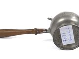 a small metal pot with a wooden handle and a tag on it